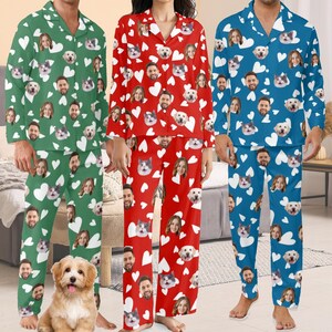 May include: Three sets of matching pajamas in green, red, and blue. Each set features a pattern of white hearts, faces, and pet faces. The pajamas include a button-down top and pants, suitable for sleepwear or lounging.
