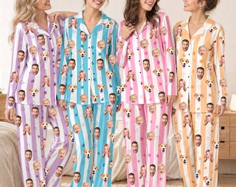 Pode incluir: Quatro conjuntos de camisas de pijama de manga comprida com botões e calças a combinar com riscas verticais roxas, azuis, cor-de-rosa e cor de laranja. Cada conjunto apresenta um padrão repetitivo de rostos humanos, cães, estrelas e corações.
