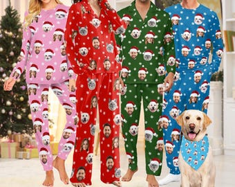 May include: Four people wearing matching Christmas pajamas with a festive pattern of snowflakes and Santa hats. The pajamas feature a repeated image of a person's face. A dog wearing a matching bandana is in the foreground.