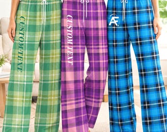Pode incluir: Três calças de pijama xadrez com cordões brancos na cintura. O par da esquerda é verde com o texto CUSTOM TEXT, o do meio é roxo com CUSTOM TEXT e o da direita é azul com um logótipo AF branco na anca.