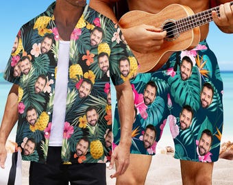 Könnte beinhalten: Zwei Personen tragen passende Hemden und Shorts mit tropischem Muster. Der Druck zeigt ein sich wiederholendes Muster aus Ananas, Palmenblättern und Hibiskusblüten. Die Hemden und Shorts sind schwarz mit grünen, rosa und gelben Akzenten.