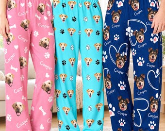 Pode incluir: Três calças de pijama em rosa, turquesa e azul-marinho, cada uma com um padrão repetitivo de rostos de cães, pegadas brancas, corações brancos, ossos brancos e o texto Cooper impresso numa fonte cursiva branca.