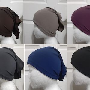 May include: Six different colors of stretchy, jersey knit headbands. The headbands are folded over and have a loose, flowing end. The colors are brown, gray, purple, dark gray, blue, and black.