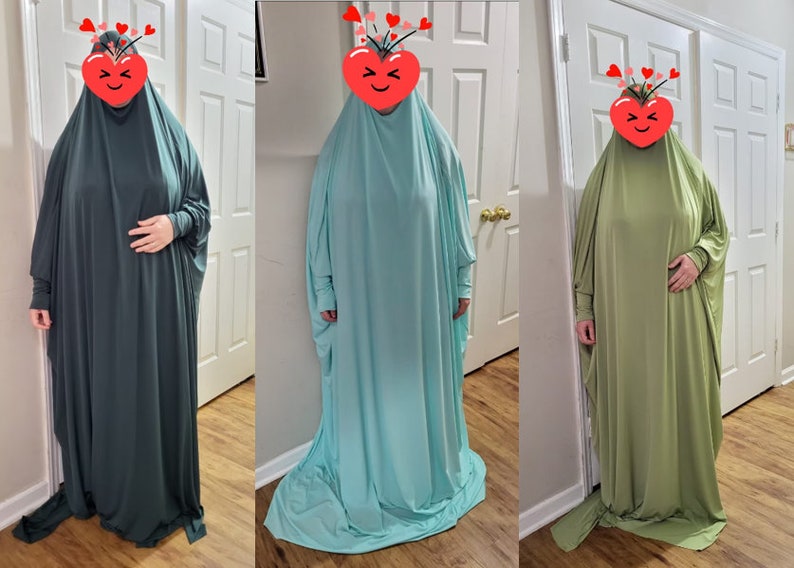 Puede incluir: Tres batas largas y fluidas de punto de jersey en diferentes colores: verde oscuro, azul claro y verde claro. Las batas tienen mangas largas y un cuello alto.