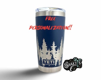 May include: A blue Yeti tumbler with a silver lid and a silver design of trees. The tumbler has the word "YETI" printed on the front. The text "FREE PERSONALIZATION!!" is printed in red above the trees.