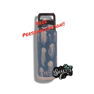 May include: A stainless steel water bottle with a blue and white design featuring jellyfish. The bottle has a black lid with a twist-open mechanism. The text "YETI" is visible on the bottle. The text "FREE PERSONALIZATION!!" is written in red on the image.