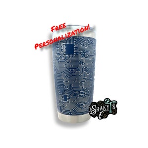 May include: A stainless steel tumbler with a navy blue background and a silver circuit board design. The tumbler has a silver rim and a black and white logo that says "SHAKY'S". The words "FREE PERSONALIZATION!" are written in red.