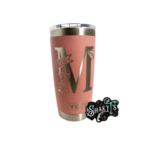 May include: A pink YETI tumbler with a gold metallic design featuring the letter "M" and the word "Teach" with a pencil, ruler, and apple graphic.