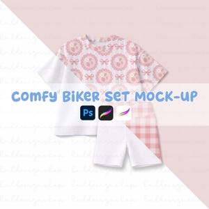 May include: White and pink children's biker set mock-up. The top features a pattern of strawberries and bows, while the shorts have a gingham pattern. The text "Comfy Biker Set MOCK-UP" is displayed in blue.