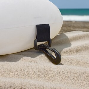 May include: A white inflatable ring with a black strap and a black plastic clip.