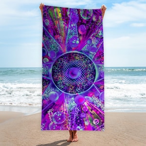 Könnte beinhalten: Ein lebendiges Strandtuch mit psychedelischem Design. Das Tuch zeigt ein zentrales kreisförmiges Muster mit komplizierten Details in Lila, Blau und Grün. Kugelförmige Formen und Sternausbrüche strahlen von der Mitte aus und erzeugen eine visuell dynamische Komposition.