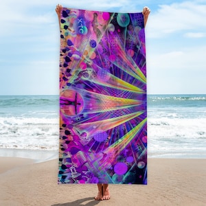 Könnte beinhalten: Ein lebendiges Strandtuch mit psychedelischem Design. Das Tuch zeigt ein komplexes Muster aus lila, rosa, gelben und blauen Farbtönen mit geometrischen Formen und abstrakten Figuren. Das Wort "XTC" ist oben links sichtbar. Das Tuch wird vor einem Strand- und Ozeanhintergrund gehalten.