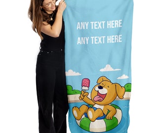 May include: Light blue beach towel with the text "ANY TEXT HERE" in white. The towel features a cartoon dog in a green and white inner tube, holding a popsicle. The dog is in a pool of water.