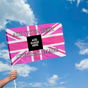 Puede incluir: Una bandera rosa con un diseño de la Union Jack blanco, con el texto "ADD YOUR TEXT" y "OPTIONAL IMAGE". Un cuadrado negro en el centro dice "ADD IMAGE HERE". La bandera se sostiene contra un cielo azul con nubes.