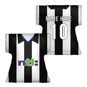 May include: Two jersey-shaped pillows. One displays black and white vertical stripes with the text "ntl:" in purple and green. The other shows the number "10" and the text "NAME HERE" in white on a black and white striped pattern.