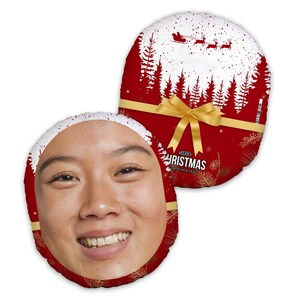 May include: Red and white round pillow with a gold bow and the text "Merry Christmas Happy New Year". The pillow has a white silhouette of a snowy forest with a red sleigh and reindeer flying through the air.