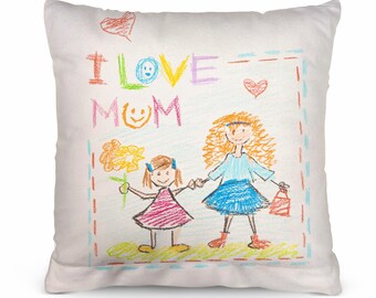 Peut inclure: Un oreiller blanc avec un dessin coloré de deux personnes se tenant la main. Le dessin dit "J'aime Maman" et comprend une fleur, des cœurs et des visages souriants.