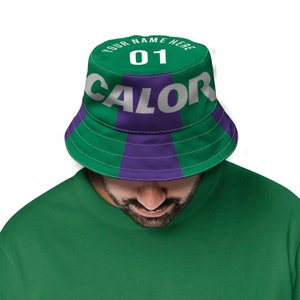 May include: A green and purple bucket hat with the text "YOUR NAME HERE" and the number "01" on the front. The word "CALOR" is printed in white letters on the hat.