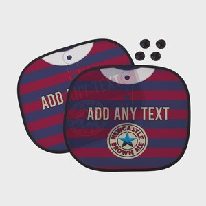 Puede incluir: Dos parasoles para coche con un dise&ntilde;o de rayas rojas y azules, que se asemeja a una camiseta. El texto "ADD ANY TEXT" es visible en la parte delantera de los parasoles, junto con un logotipo de Newcastle Brown Ale. Incluye cuatro ventosas negras.