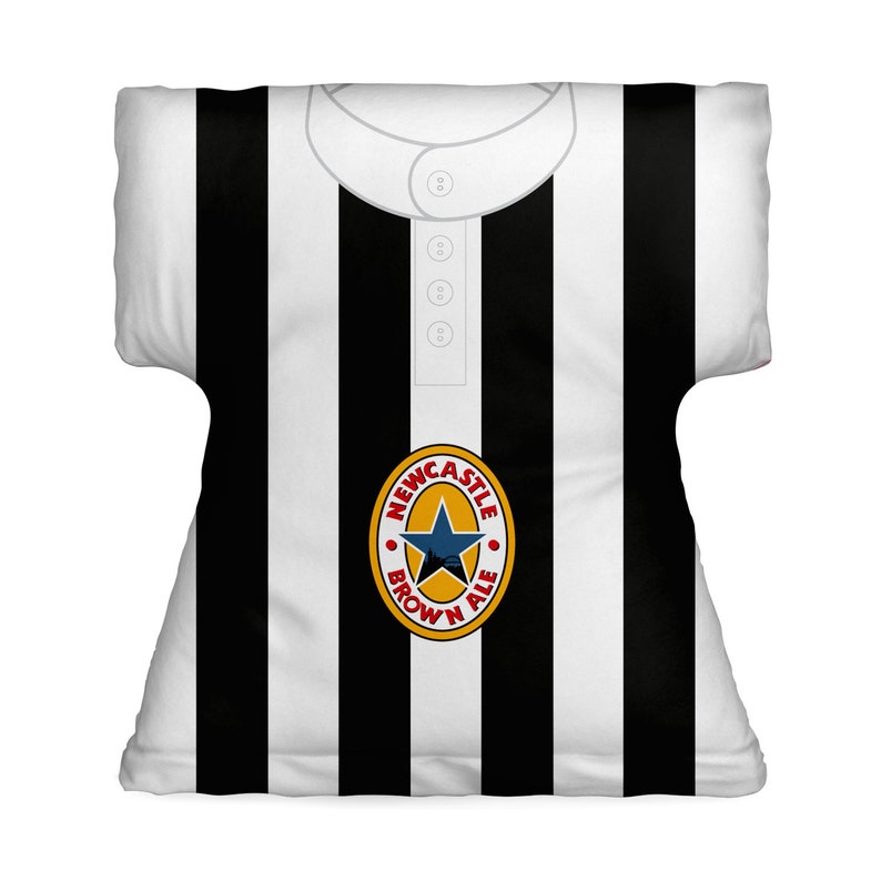 May include: A black and white striped pillow with a Newcastle Brown Ale logo in the center. The logo is a circle with a star and the words "Newcastle Brown Ale" around it.