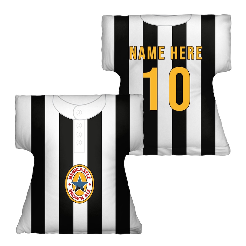 May include: Two black and white striped pillows shaped like a football jersey. One pillow has the text "NAME HERE" and the number "10" in yellow. The other pillow has a Newcastle Brown Ale logo.
