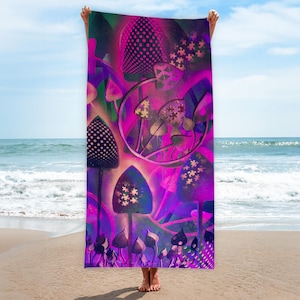 Könnte beinhalten: Ein lebendiges Strandtuch mit einem psychedelischen Pilzdesign in Lila, Pink und Grün. Das Tuch zeigt verschiedene Pilzformen mit komplizierten Mustern und einem kreisförmigen Designelement. Das Tuch wird an einem Strand hochgehalten.