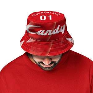 Pode incluir: Chapéu de balde vermelho com texto branco que diz "YOUR NAME HERE" e "Candy" com o número "01" no centro.