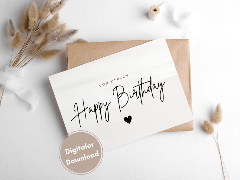 May include: A white card with black text that says "Von Herzen Happy Birthday" with a small black heart. The card is on a brown envelope and there is a white background.