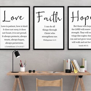May include: Three black framed prints with white backgrounds and black text. The prints feature the words "Love", "Faith", and "Hope" with bible verses underneath each word.