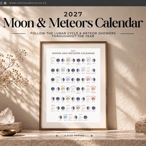 以下が含まれることがあります： 2027年版の月と流星カレンダーの額入りプリント。月の満ち欠けと流星群の日付がグリッド状に配置されています。白いポスターには「2027 MOONS AND METEORS CALENDAR」という文字と、月のサイクルや流星のカラフルなイラストが描かれています。