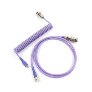 May include: A coiled, lavender-colored keyboard cable with a USB-A connector and a USB-C connector. The cable has a metal aviator connector and a push-button connector. The cable is designed for mechanical keyboards.