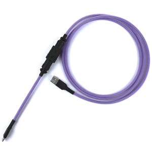 Peut inclure: Câble USB lavande enroulé, avec un connecteur noir et un connecteur USB-A. Le câble a une texture tressée et est conçu pour connecter des appareils. Le fond est blanc uni.