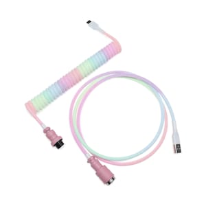 May include: A pastel-coloured coiled keyboard cable with a USB connector and a pink connector. The coiled section transitions through shades of pink, green, and blue. The straight cable section has a gradient of pink, green, and purple.