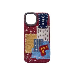 May include: A burgundy phone case with a patchwork design. It features fabric patches in blue, yellow, white, and red, stitched together. The camera aperture has a grey border.
