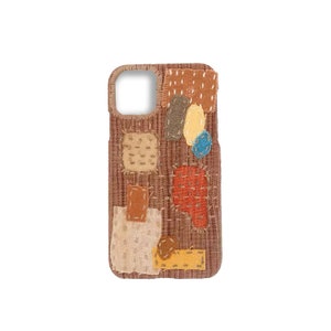 May include: A brown phone case with a patchwork design. The case is made of different fabrics in shades of brown, orange, yellow, and blue. The fabric pieces are sewn together with visible stitching.