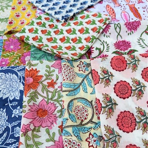 May include: A collection of colorful fabric squares with floral and geometric patterns. The fabrics are arranged in a random pattern, creating a visually appealing display.