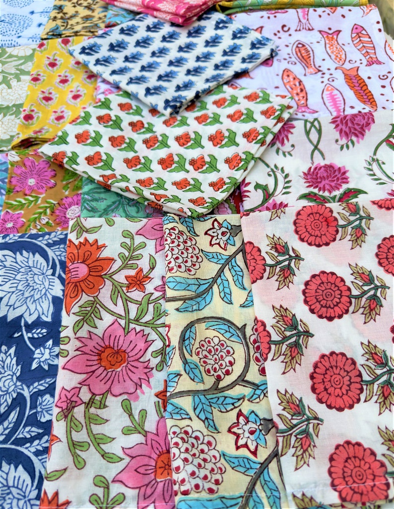 May include: A collection of colorful fabric squares with floral and geometric patterns. The fabrics are arranged in a random pattern, creating a visually appealing display.