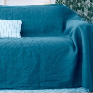 Peut inclure: Une couverture en lin bleu sarcelle drap&eacute; sur un canap&eacute;. La couverture est douce et textur&eacute;e, et elle serait parfaite pour ajouter une touche de couleur et de chaleur &agrave; n'importe quel salon.