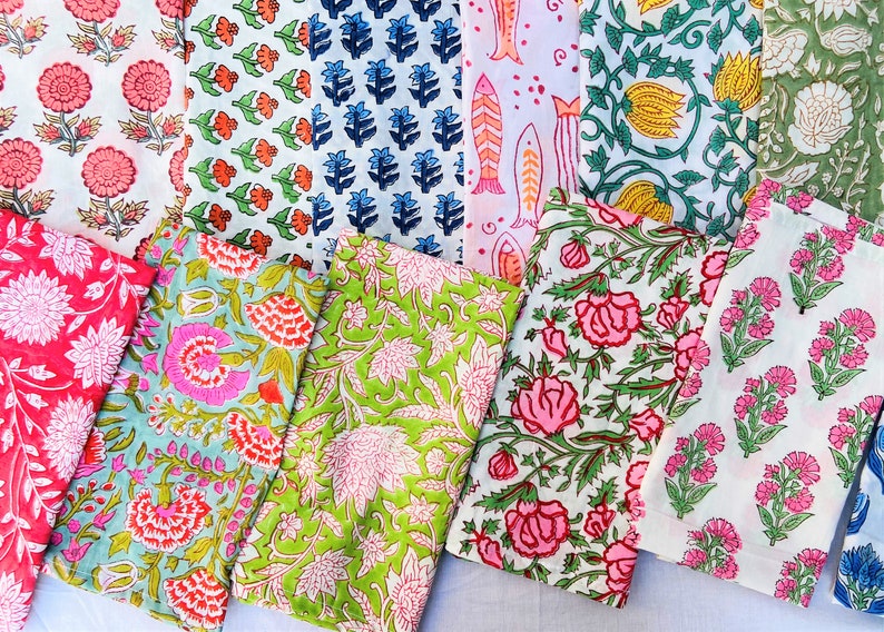 May include: A collection of colorful fabric napkins with floral and geometric patterns. The napkins are made of cotton and are perfect for adding a touch of style to any table setting.