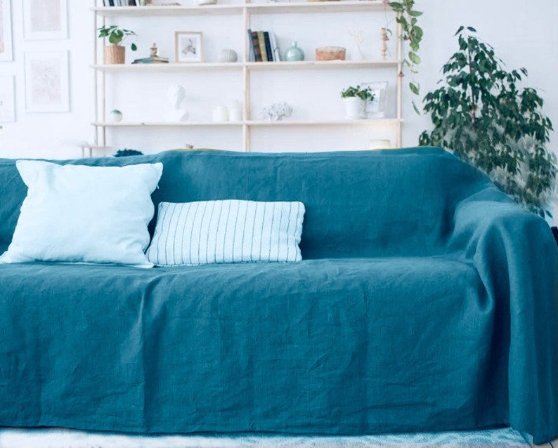 Peut inclure: Un canap&eacute; bleu sarcelle avec deux coussins bleu clair et un coussin ray&eacute; blanc et bleu. Le canap&eacute; est recouvert d'une couverture en fourrure bleu sarcelle.