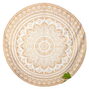 May include: A round white and gold mandala tapestry with intricate details. The mandala is a circular design with a central motif and radiating patterns.