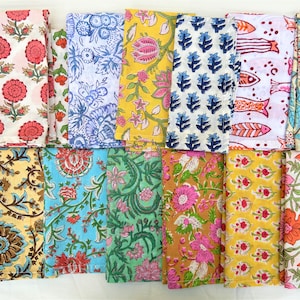 May include: A set of 16 colorful cotton napkins with various floral and geometric patterns. The napkins are arranged in four rows of four, with each napkin featuring a unique design.