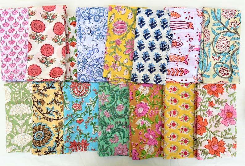 May include: A set of 16 colorful cotton napkins with various floral and geometric patterns. The napkins are arranged in four rows of four, with each napkin featuring a unique design.