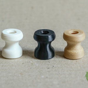 May include: Three small, round, 3D printed knobs in white, black, and beige.