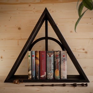 Può includere: Una libreria triangolare nera a forma del simbolo dei Doni della Morte della serie di Harry Potter. La libreria contiene un set di sette libri di Harry Potter.