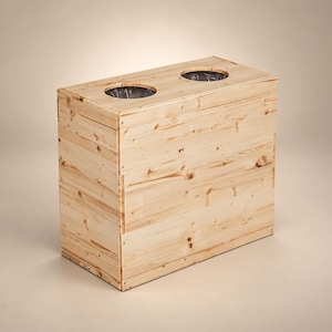 Può includere: Un contenitore per rifiuti rettangolare in legno chiaro con due aperture circolari sulla superficie superiore. La venatura naturale del legno è visibile su tutta la struttura, assemblata con piccole viti metalliche lungo i bordi e gli angoli.