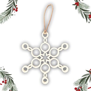 Può includere: Ornamento a forma di fiocco di neve in legno color crema con un anello in spago naturale per appenderlo. Il design del fiocco di neve presenta una stella a sei punte al centro, circondata da forme circolari e allungate. Una decorazione natalizia festosa.
