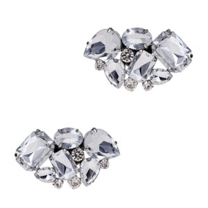 May include: Two pairs of clear crystal shoe clips in a heart shape. Each clip features a cluster of rhinestones and clear crystals.