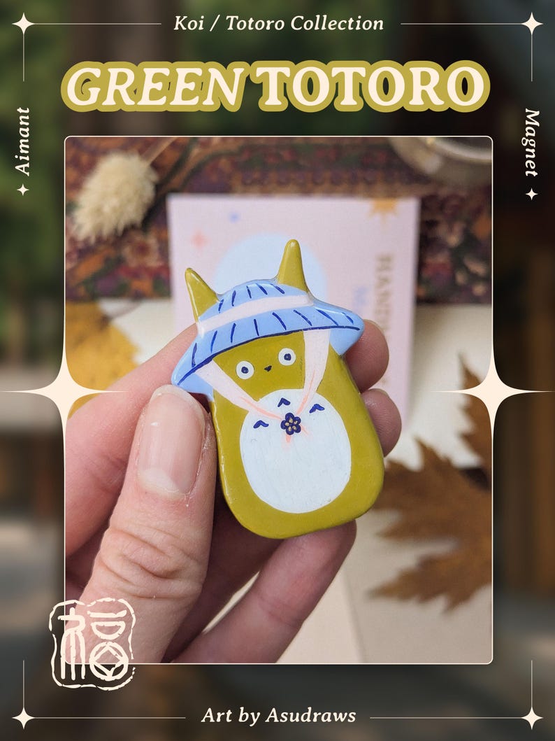 May include: A Green Totoro magnet from the Koi / Totoro Collection. The magnet features a yellow Totoro character with a blue and white hat. The text "GREEN TOTORO" is displayed above the character. The art is by Asudraws.