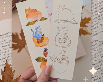 Puede incluir: Dos marcapáginas con ilustraciones de gatos y melocotones. Un marcapáginas presenta un diseño de gato y melocotón a color, mientras que el otro tiene un dibujo lineal. Los textos "Bookmark" y "Marque-page" son visibles.